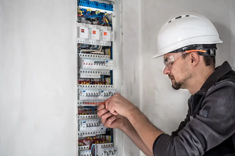 Elettricista a Brescia mentre aggiorna un quadro elettrico datato