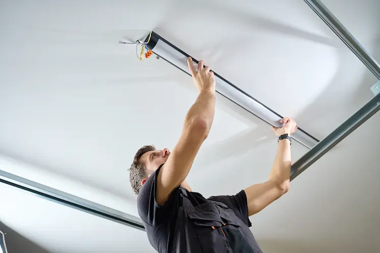 Elettricista a Brescia mentre ripara un sistema di illuminazione LED